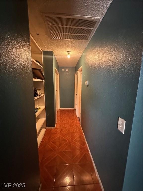 corridor with baseboards and visible vents