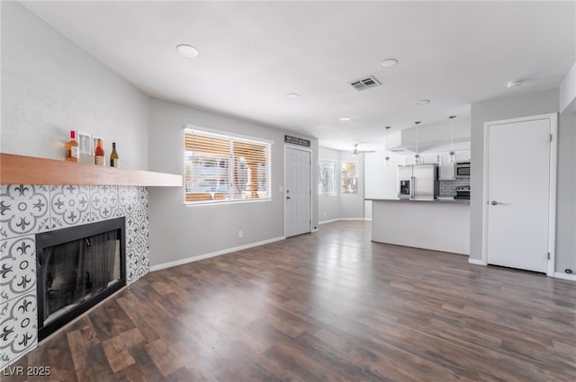 912 Falconhead Ln Unit 101, Las Vegas, NV 89128 - unfurnished living room featuring a fireplace, dark wood finished floors, recessed lighting, baseboards, and visible vents