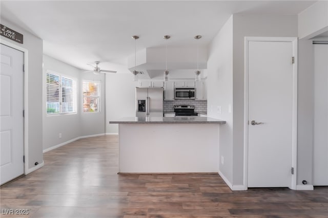 912 Falconhead Ln Unit 101, Las Vegas, NV 89128 - kitchen featuring dark wood finished floors, appliances with stainless steel finishes, tasteful backsplash, and a peninsula