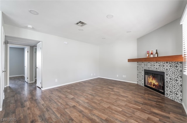 912 Falconhead Ln Unit 101, Las Vegas, NV 89128 - unfurnished living room featuring visible vents, dark wood-style flooring, baseboards, and a fireplace
