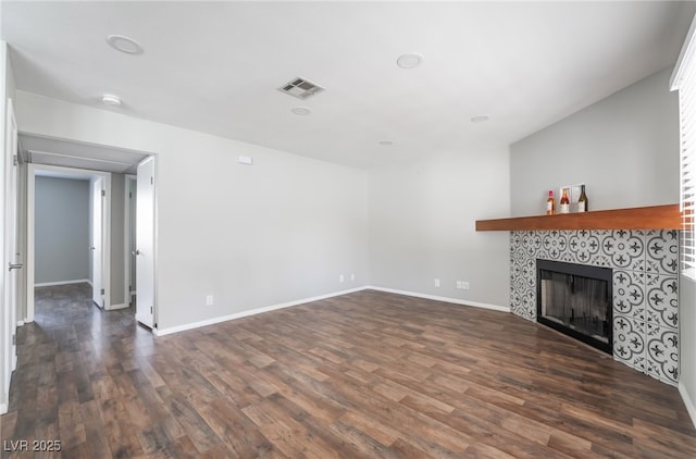 912 Falconhead Ln Unit 101, Las Vegas, NV 89128 - unfurnished living room with baseboards, visible vents, dark wood-style floors, and a tiled fireplace