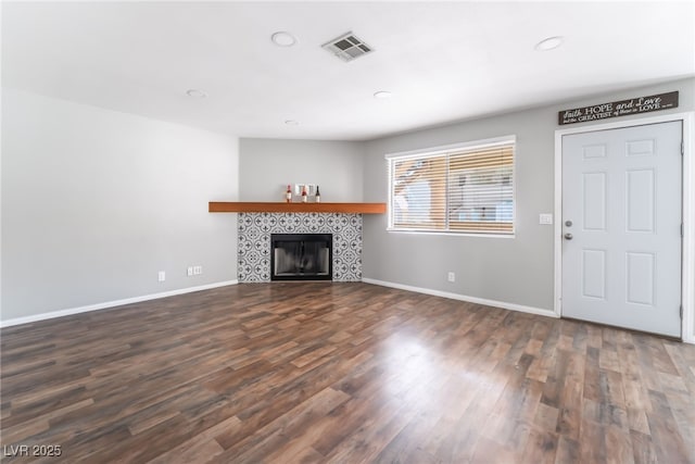 912 Falconhead Ln Unit 101, Las Vegas, NV 89128 - unfurnished living room with visible vents, baseboards, recessed lighting, a tile fireplace, and dark wood finished floors
