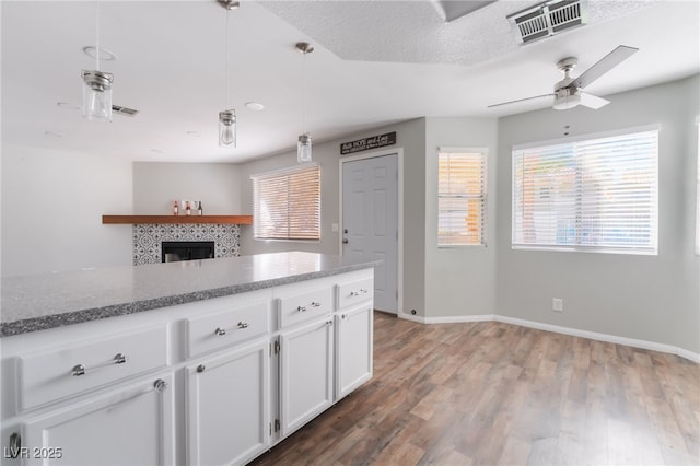912 Falconhead Ln Unit 101, Las Vegas, NV 89128 - kitchen featuring white cabinetry, ceiling fan, visible vents, and a healthy amount of sunlight