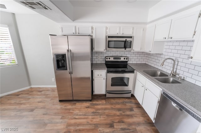 912 Falconhead Ln Unit 101, Las Vegas, NV 89128 - kitchen featuring visible vents, white cabinetry, tasteful backsplash, a sink, and appliances with stainless steel finishes