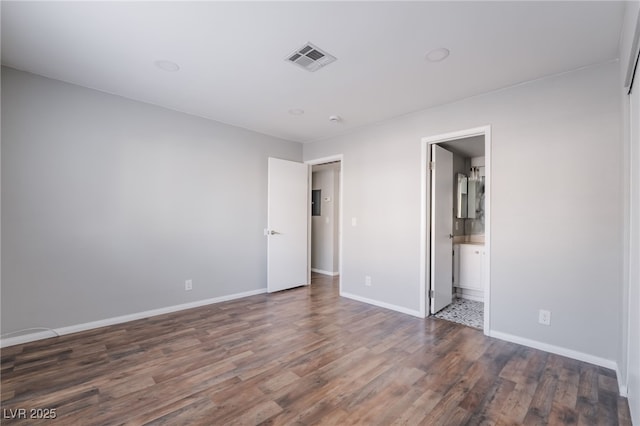 912 Falconhead Ln Unit 101, Las Vegas, NV 89128 - unfurnished bedroom with visible vents, baseboards, ensuite bath, and wood finished floors