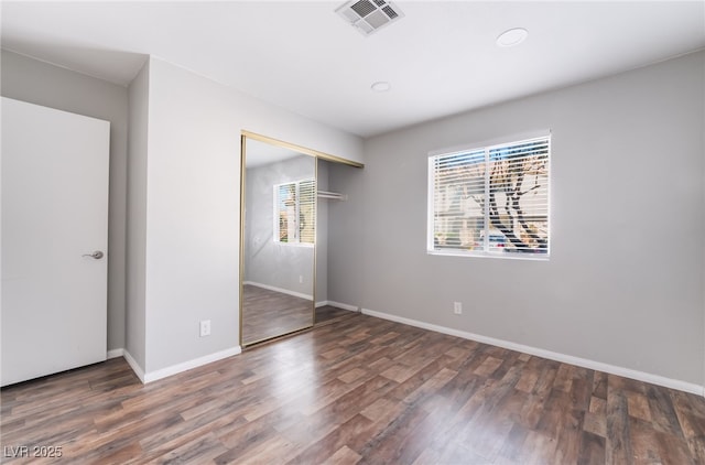 912 Falconhead Ln Unit 101, Las Vegas, NV 89128 - unfurnished bedroom featuring baseboards, a closet, wood finished floors, and visible vents