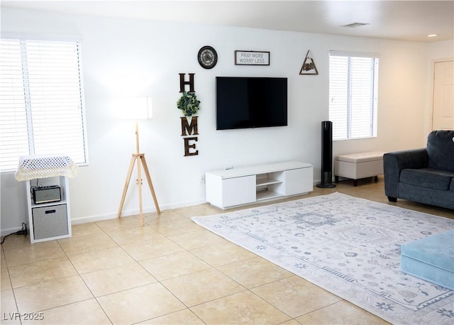 living area with baseboards, visible vents, and light tile patterned floors