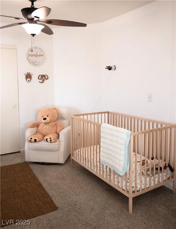 bedroom featuring carpet floors, a ceiling fan, and a nursery area