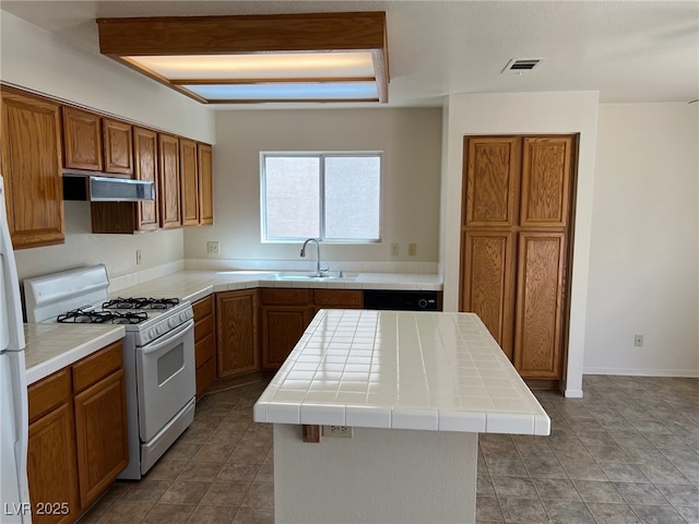 1249 Lucia Dr, Las Vegas, NV 89128 - kitchen featuring visible vents, gas range gas stove, tile counters, under cabinet range hood, and a sink