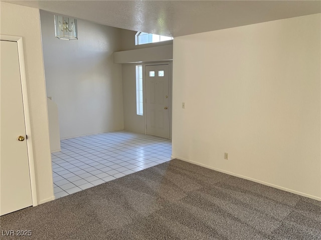 1249 Lucia Dr, Las Vegas, NV 89128 - tiled empty room featuring an inviting chandelier, carpet flooring, and a wealth of natural light