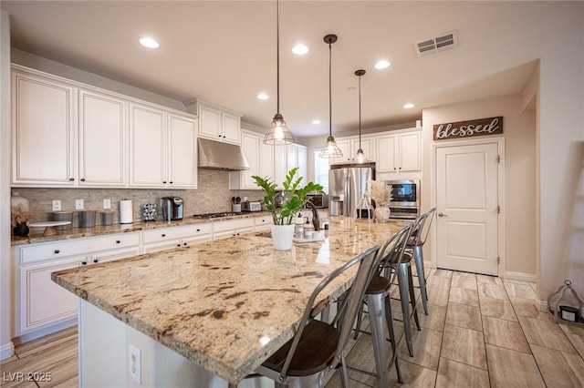 2198 Maderno St, Henderson, NV 89044 - kitchen featuring backsplash, visible vents, stainless steel appliances, under cabinet range hood, and white cabinetry
