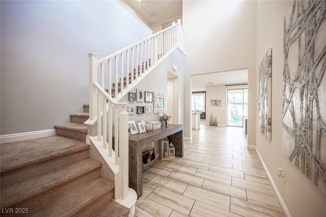 2198 Maderno St, Henderson, NV 89044 - stairs with baseboards, wood tiled floor, and a towering ceiling