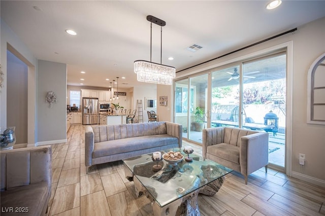 2198 Maderno St, Henderson, NV 89044 - living area featuring visible vents, baseboards, wood finish floors, recessed lighting, and ceiling fan with notable chandelier