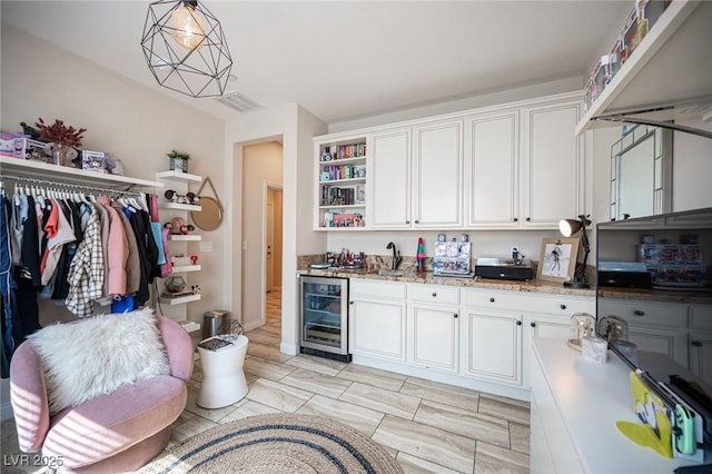 2198 Maderno St, Henderson, NV 89044 - interior space featuring white cabinets, beverage cooler, open shelves, and a sink