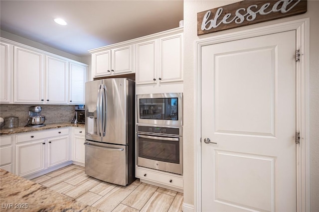 2198 Maderno St, Henderson, NV 89044 - kitchen with light stone counters, white cabinets, stainless steel appliances, and tasteful backsplash