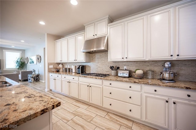 2198 Maderno St, Henderson, NV 89044 - kitchen featuring light stone counters, under cabinet range hood, tasteful backsplash, and stainless steel gas stovetop