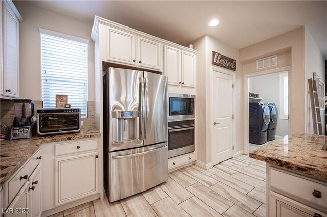 2198 Maderno St, Henderson, NV 89044 - kitchen with decorative backsplash, a toaster, white cabinetry, separate washer and dryer, and appliances with stainless steel finishes
