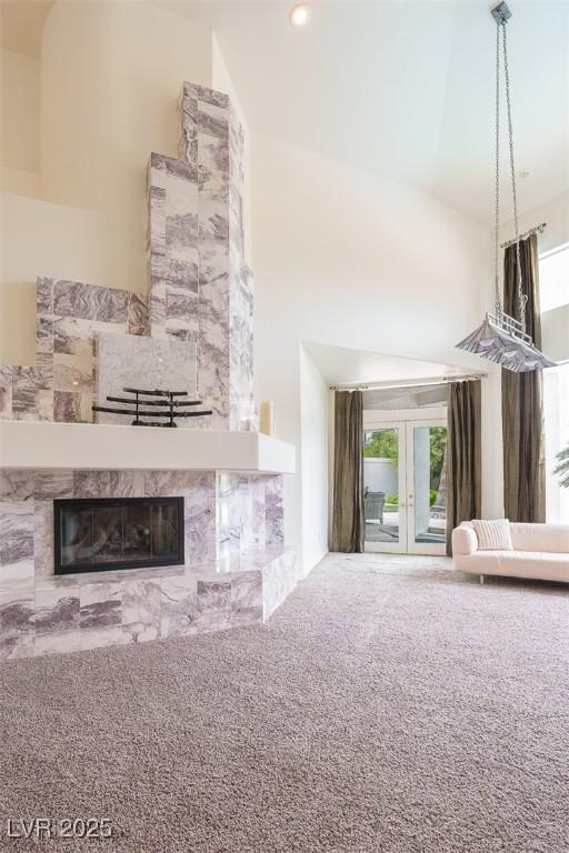 72 Innisbrook Ave, Las Vegas, NV 89113 - unfurnished living room featuring a tiled fireplace, carpet floors, and a high ceiling