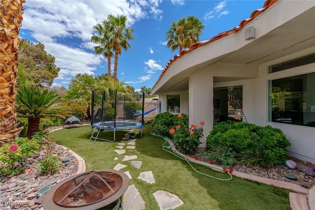 72 Innisbrook Ave, Las Vegas, NV 89113 - view of green lawn with a trampoline and an outdoor fire pit