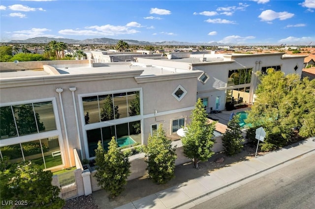 exterior space featuring a mountain view and stucco siding