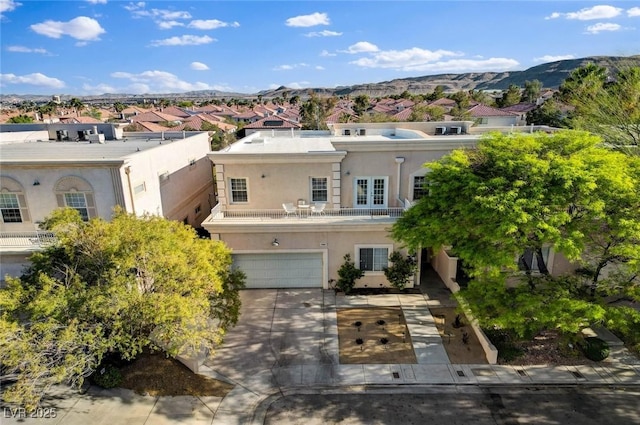 view of front facade with a residential view, a mountain view, stucco siding, and an attached garage