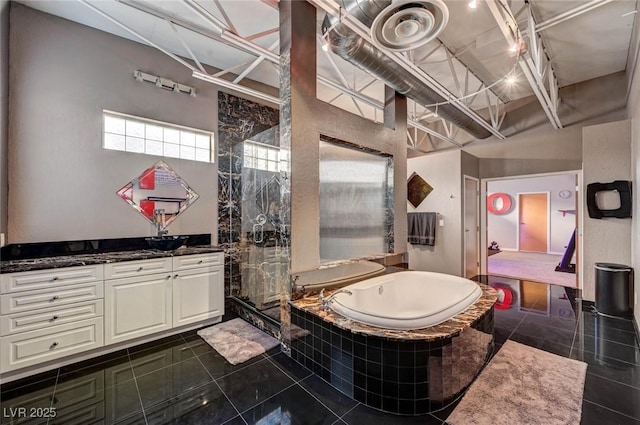 bathroom with vanity, tile patterned flooring, a garden tub, and tiled shower