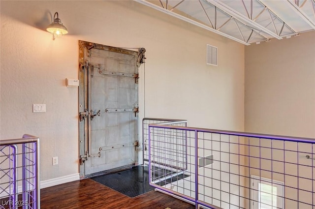 interior space with baseboards, wood finished floors, and visible vents