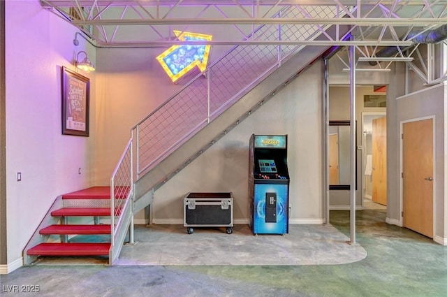 stairway featuring baseboards and concrete flooring