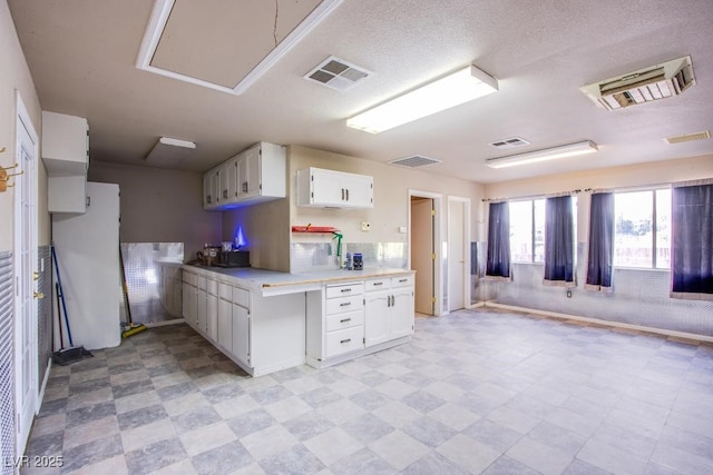 5180 N Dapple Gray Rd, Las Vegas, NV 89149 - kitchen featuring light flooring, light countertops, white cabinets, open floor plan, and freestanding refrigerator