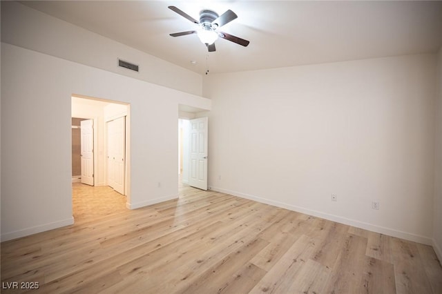 empty room featuring visible vents, a ceiling fan, light wood finished floors, and baseboards