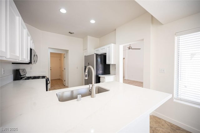 kitchen featuring a sink, appliances with stainless steel finishes, white cabinets, and visible vents