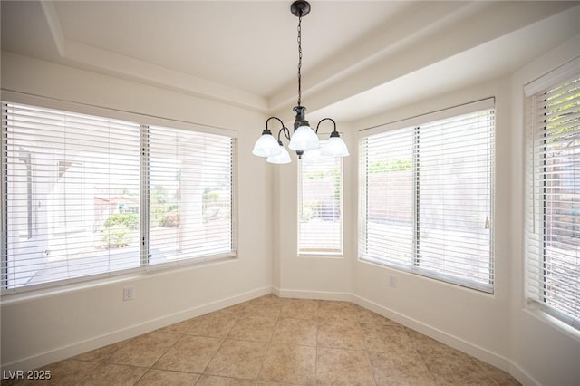 unfurnished dining area with baseboards, a tray ceiling, a notable chandelier, and light tile patterned floors