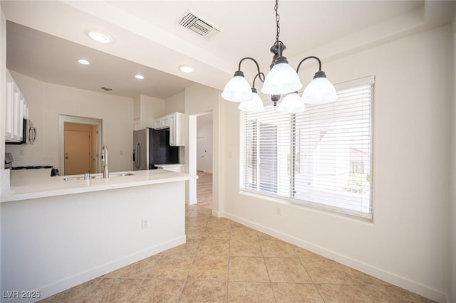 kitchen with visible vents, appliances with stainless steel finishes, a sink, baseboards, and an inviting chandelier