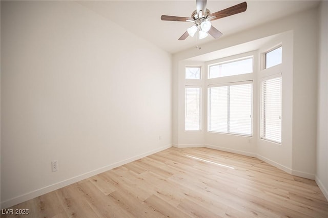 spare room featuring baseboards, a ceiling fan, and light wood finished floors