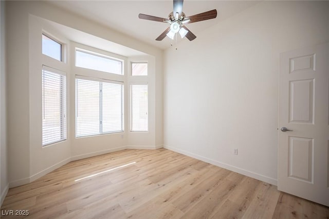 spare room with baseboards, plenty of natural light, and ceiling fan