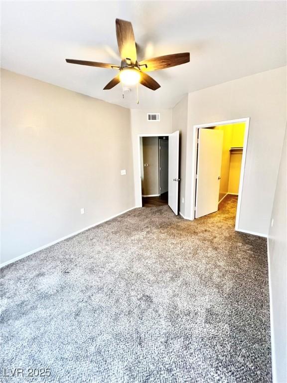 1881 W Alexander Rd Unit 1128, North Las Vegas, NV 89032 - unfurnished bedroom with carpet, a closet, a ceiling fan, and a walk in closet