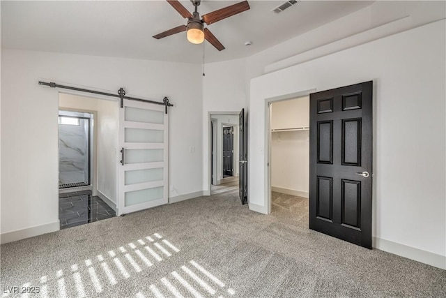 7413 Red Eagle St, Las Vegas, NV 89131 - unfurnished bedroom with carpet, a spacious closet, a barn door, and baseboards