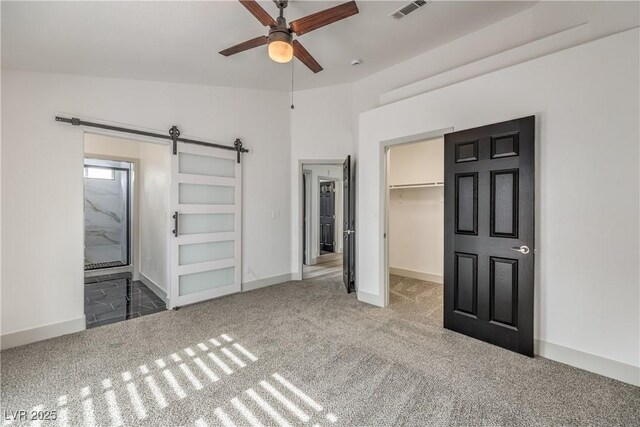 7413 Red Eagle St, Las Vegas, NV 89131 - unfurnished bedroom with carpet, a spacious closet, a barn door, and baseboards