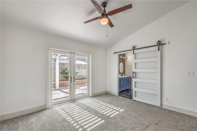 7413 Red Eagle St, Las Vegas, NV 89131 - unfurnished bedroom featuring access to outside, a barn door, carpet flooring, vaulted ceiling, and ensuite bath
