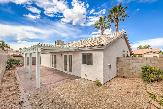 7413 Red Eagle St, Las Vegas, NV 89131 - back of property featuring a pergola, a fenced backyard, stucco siding, a tiled roof, and french doors