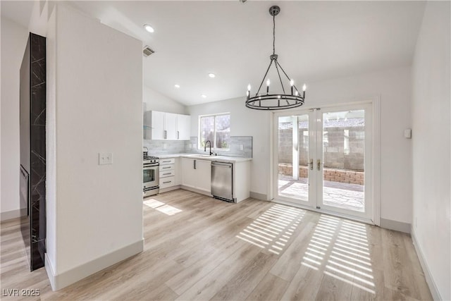 7413 Red Eagle St, Las Vegas, NV 89131 - kitchen with appliances with stainless steel finishes, a sink, a chandelier, light countertops, and white cabinetry