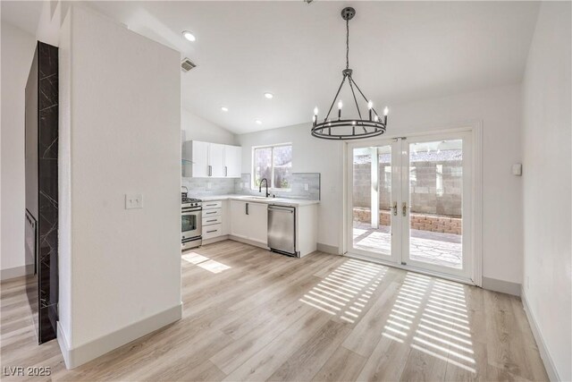7413 Red Eagle St, Las Vegas, NV 89131 - kitchen with appliances with stainless steel finishes, a sink, a chandelier, light countertops, and white cabinetry