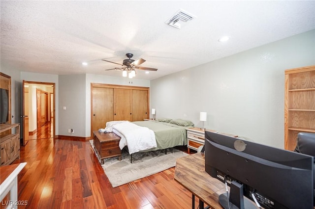 bedroom with a ceiling fan, visible vents, wood-type flooring, a closet, and recessed lighting