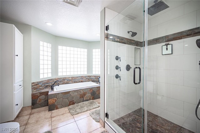 bathroom featuring a textured ceiling, visible vents, a garden tub, and a stall shower