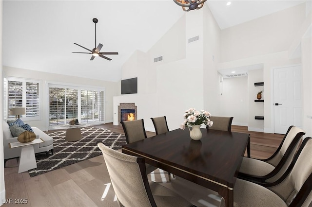6961 Emerald Springs Ln, Las Vegas, NV 89113 - dining room with a glass covered fireplace, wood finished floors, a ceiling fan, high vaulted ceiling, and recessed lighting
