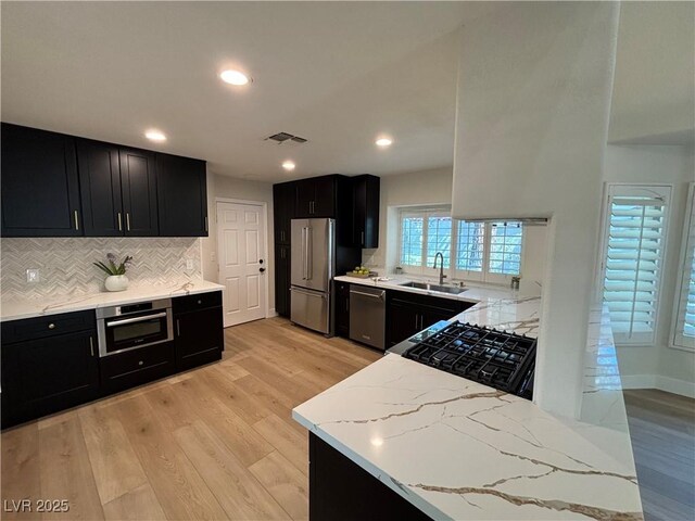 6961 Emerald Springs Ln, Las Vegas, NV 89113 - kitchen featuring dark cabinetry, appliances with stainless steel finishes, a sink, tasteful backsplash, and recessed lighting