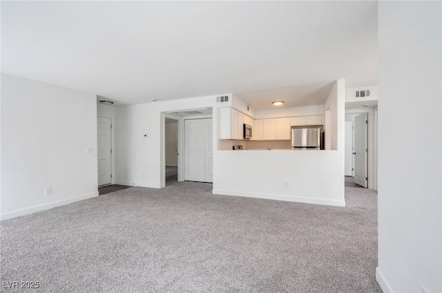 unfurnished living room featuring baseboards, light carpet, and visible vents