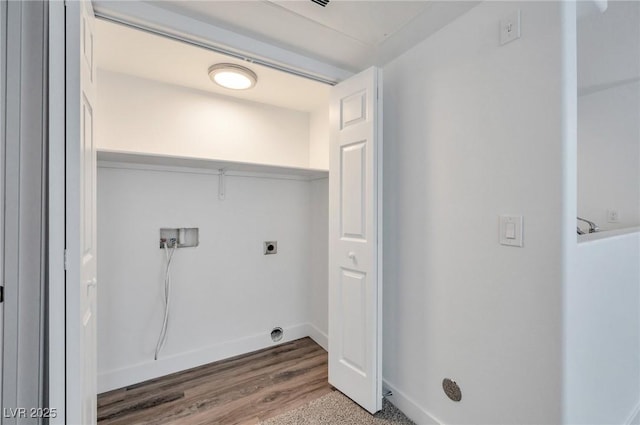 laundry area featuring laundry area, hookup for a washing machine, electric dryer hookup, baseboards, and wood finished floors