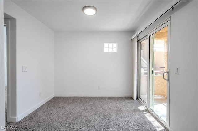 spare room with baseboards and carpet flooring