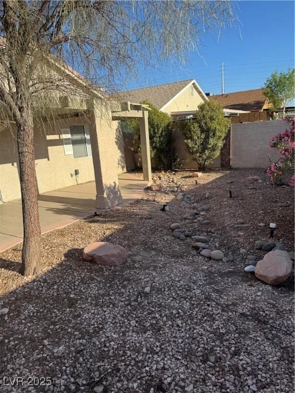 exterior space with fence, a patio, and stucco siding